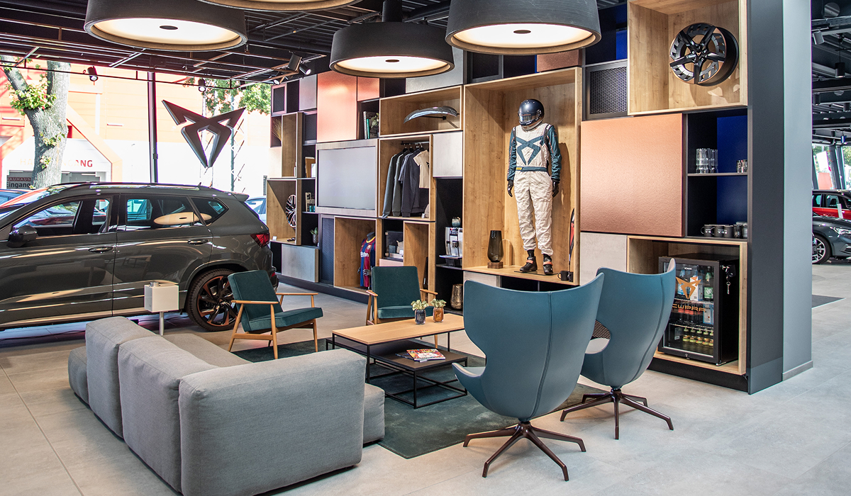 Innenansicht der CUPRA Garage Hamburg mit weißem CUPRA Modell, modernen Einrichtungselementen und Lounge-Bereich